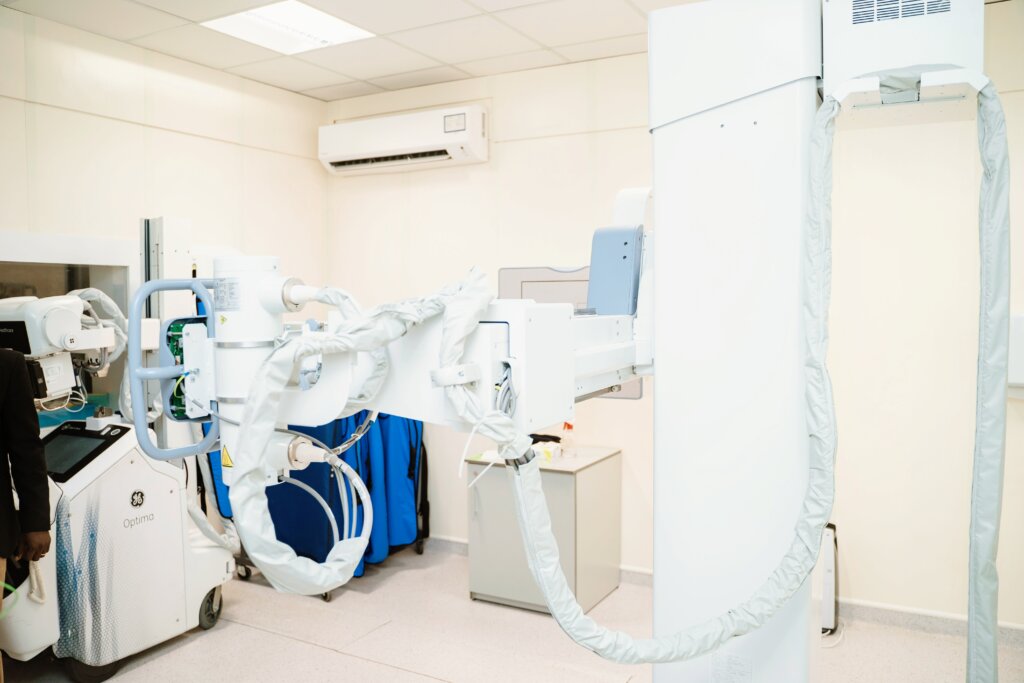 This image features advanced medical imaging equipment in a bright, sterile room at Marcelle Ruth healthcare facilities. The modern setup, including a GE Optima machine, underscores Marcelle Ruth's commitment to cutting-edge diagnostic services and high standards of care.