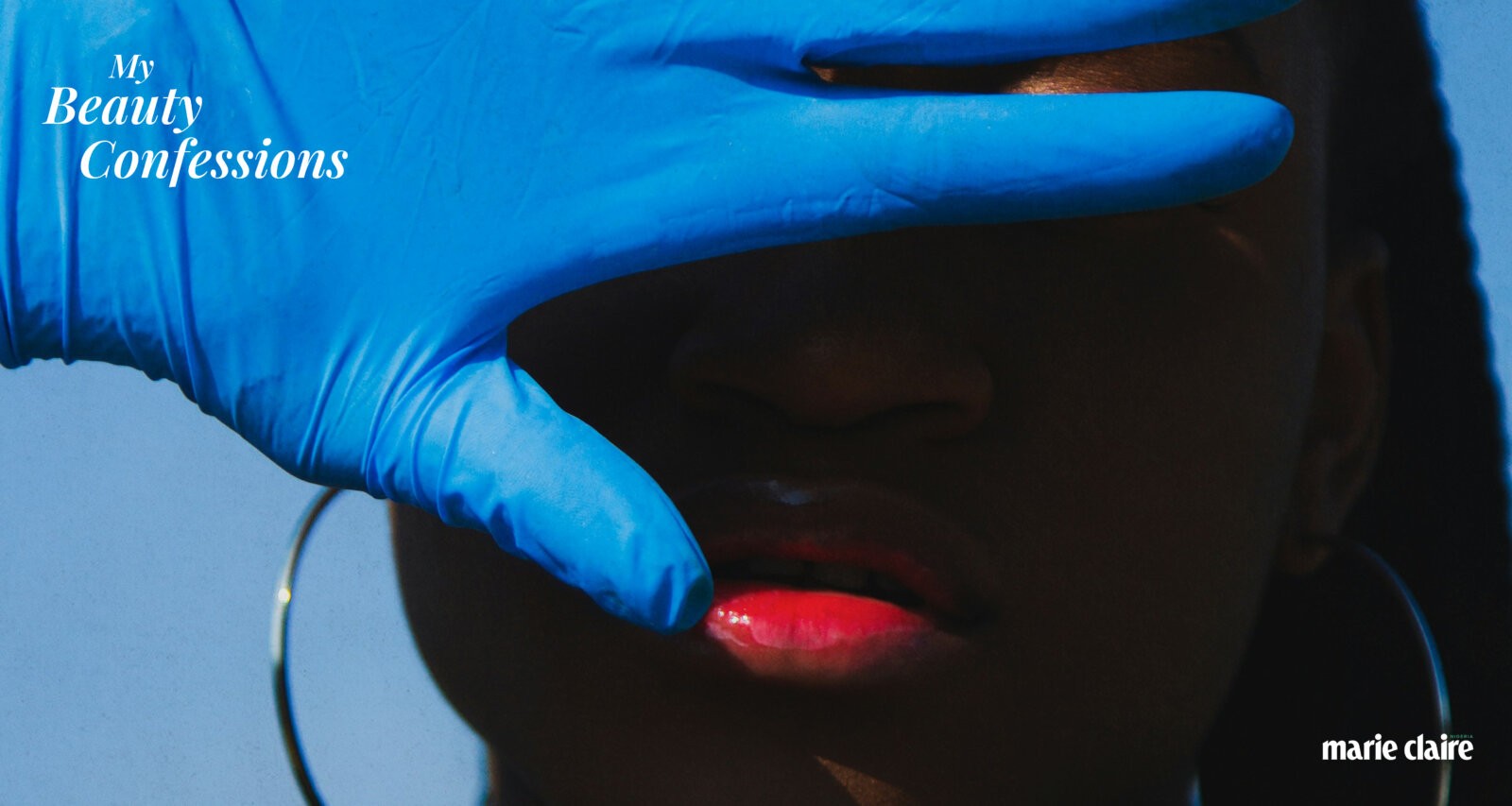 A black woman wearing a blue glove and covering her face via Unsplash