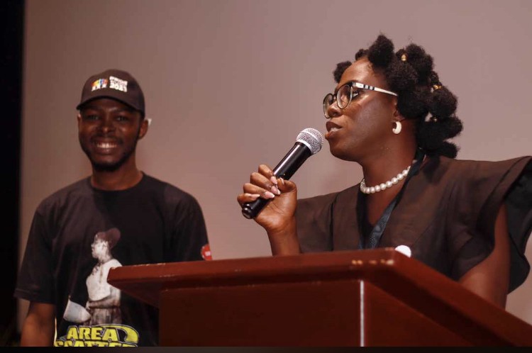 Adunni Tiwatope addressing the audience at the Pride In Lagos symposium while co-founder Olukayode Timileyin looks on. 