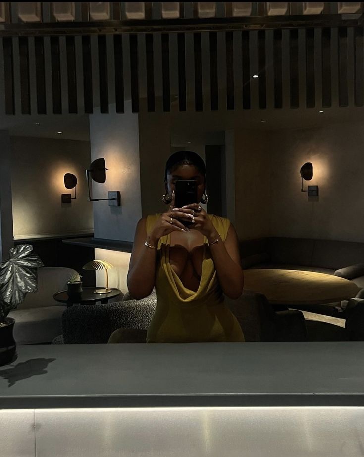 Woman taking a mirror selfie in a restaurant via Pinterest