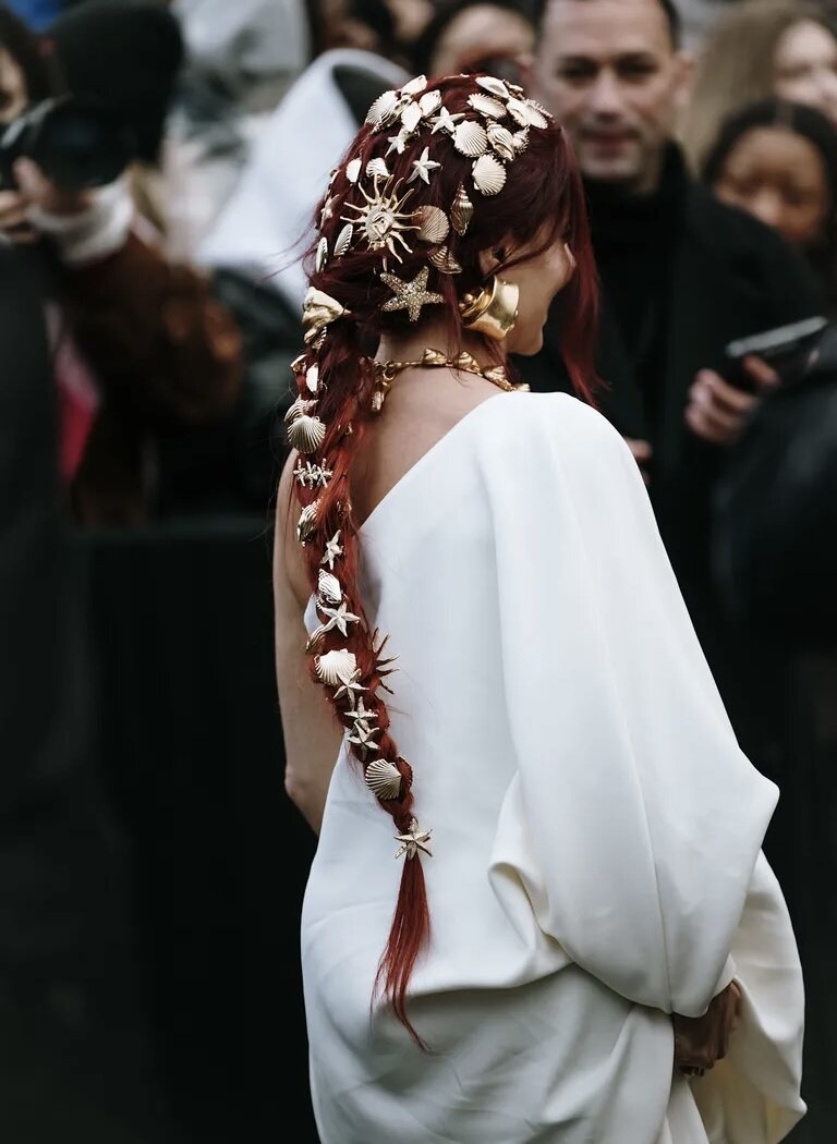 A woman’s hair adorned with delicate sea shell accessories, via RAIMONDA KULIKAUSKIENE for Getty Images.