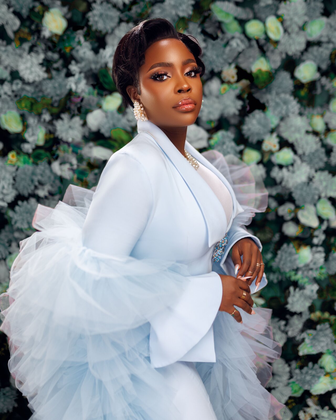  A portrait of Lade Ibikunle wearing a white pant suit set with tulle ruffles