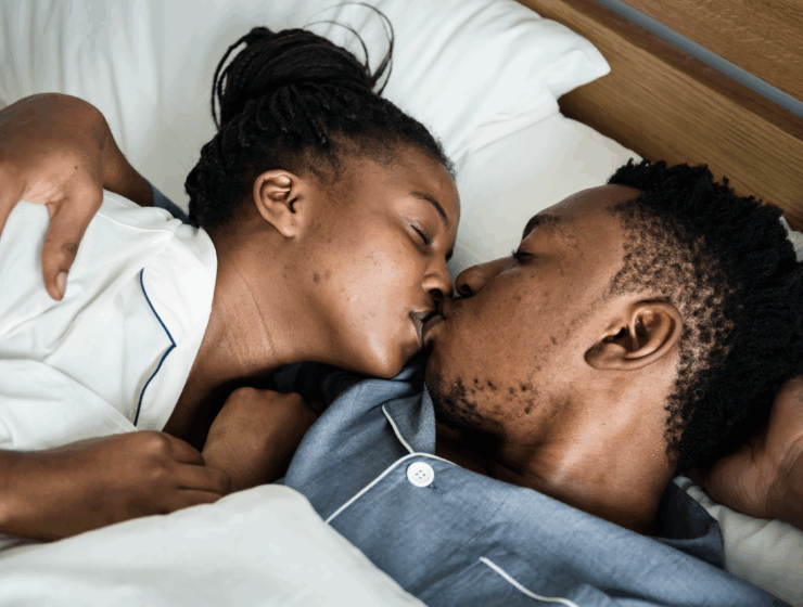 A couple kssing in bed via Freepik.